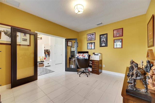 office area featuring a textured ceiling, french doors, visible vents, and baseboards