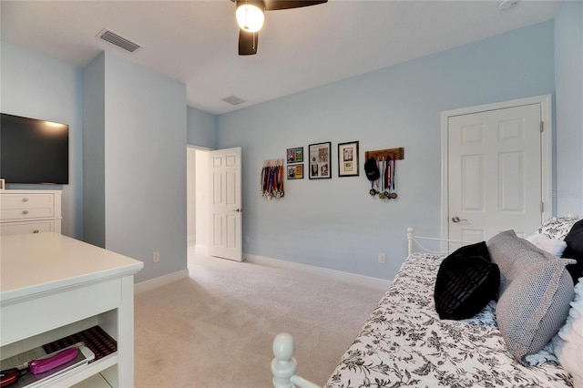 bedroom with light carpet, ceiling fan, visible vents, and baseboards