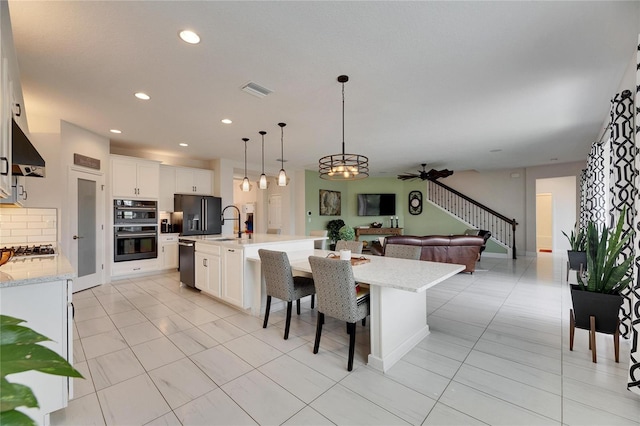 kitchen with recessed lighting, visible vents, open floor plan, white cabinetry, and black appliances