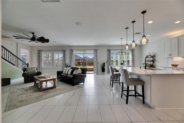 living area featuring recessed lighting, visible vents, ceiling fan, stairs, and light tile patterned flooring