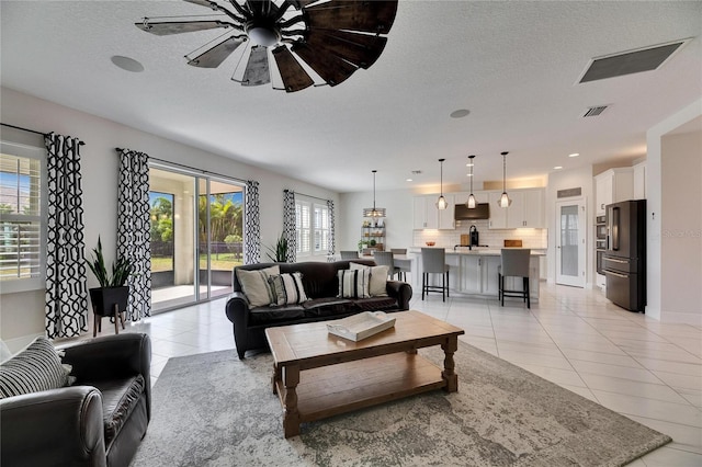 living room with light tile patterned floors, ceiling fan, a textured ceiling, and recessed lighting