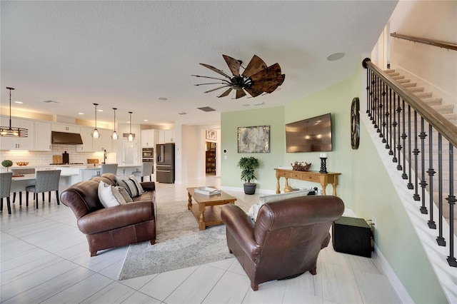 living room featuring baseboards, visible vents, stairway, and recessed lighting