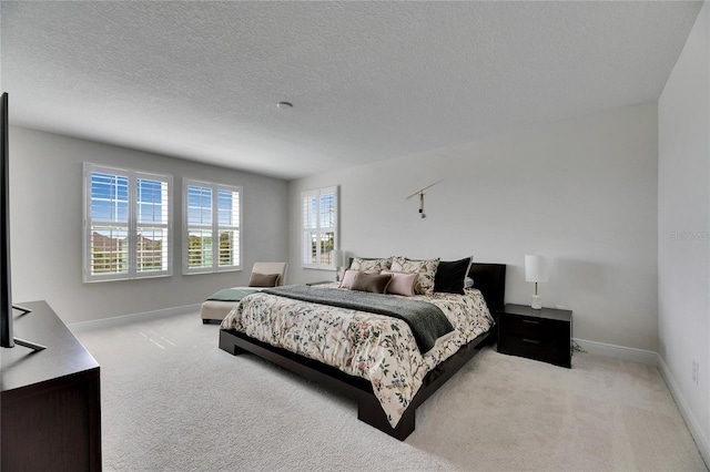 carpeted bedroom featuring a textured ceiling and baseboards