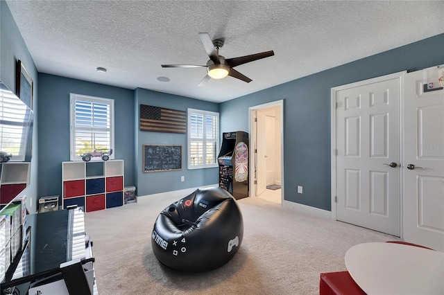 playroom with a healthy amount of sunlight, carpet, ceiling fan, and a textured ceiling