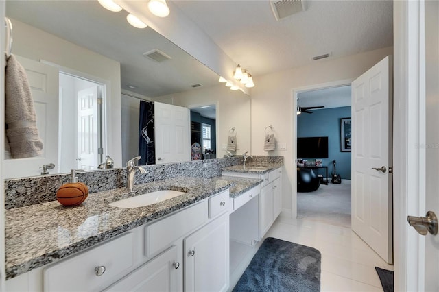 bathroom with double vanity, visible vents, and a sink