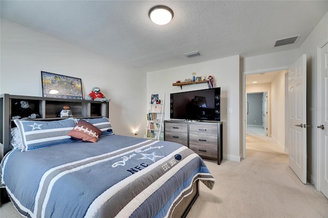 bedroom featuring baseboards, visible vents, light carpet, and a textured ceiling