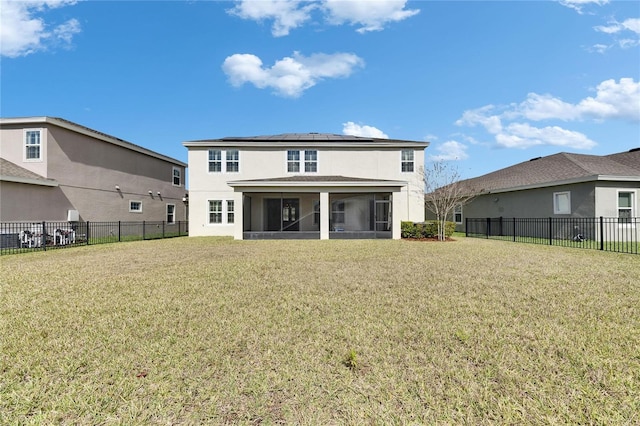 rear view of house with a sunroom, a fenced backyard, a yard, and roof mounted solar panels