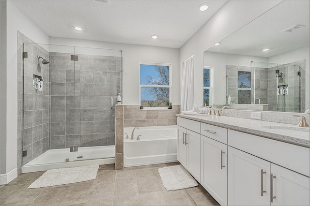 bathroom featuring a garden tub, a stall shower, and a sink