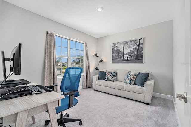 office area featuring light carpet and baseboards