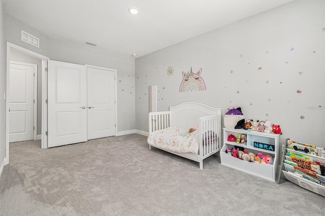 bedroom with light carpet, a nursery area, and visible vents