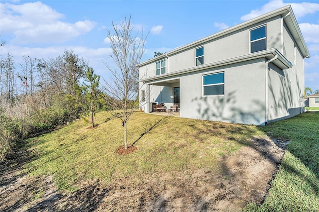 22990 Scaglione Dr, Lutz, FL 33549 - back of house featuring a yard, stucco siding, and a patio area