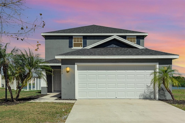 view of front property featuring a garage and a yard