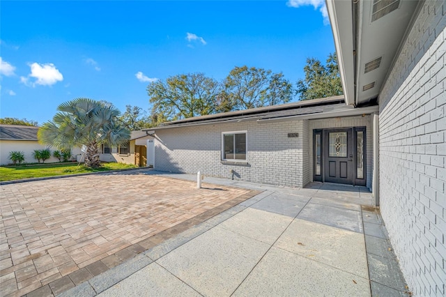 view of exterior entry featuring a patio