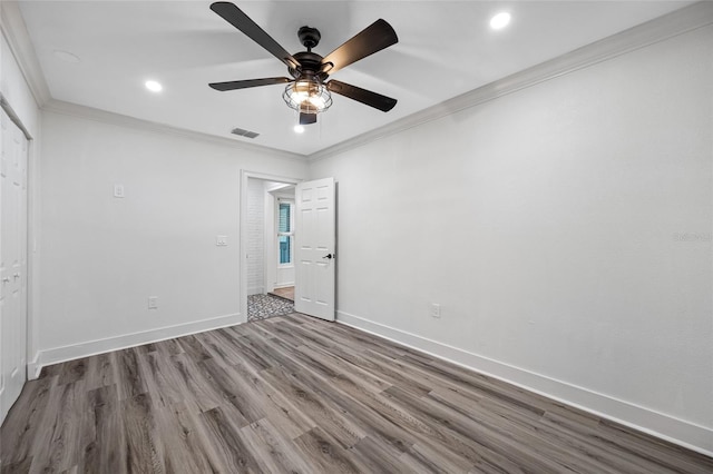 unfurnished bedroom with hardwood / wood-style floors, ornamental molding, and ceiling fan