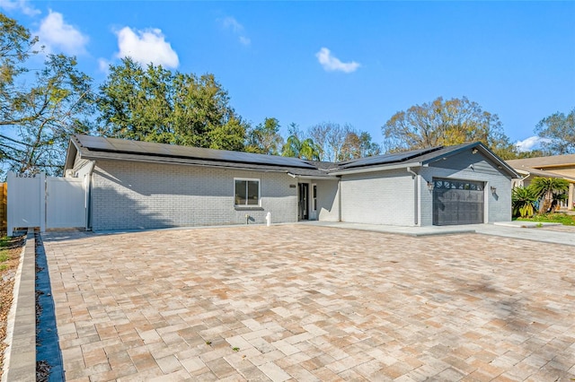 view of front of house featuring a garage and solar panels