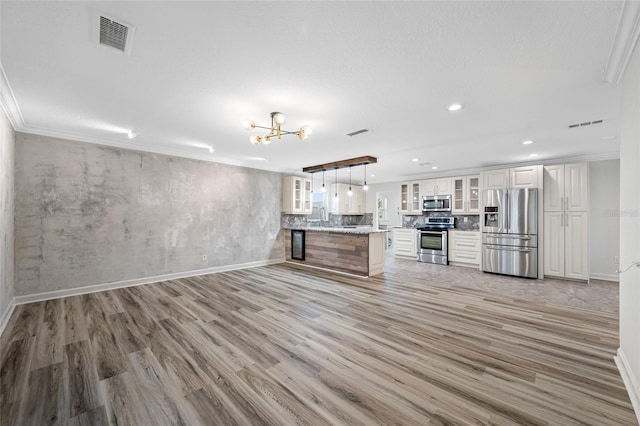 unfurnished living room featuring ornamental molding, sink, and light hardwood / wood-style floors