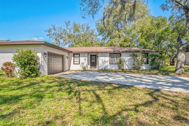 ranch-style home featuring a garage and a front lawn