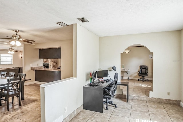 office featuring light tile patterned floors, a textured ceiling, and ceiling fan