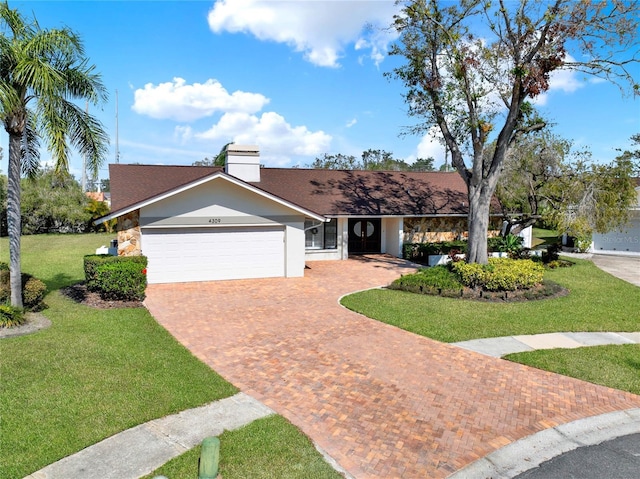 single story home featuring a garage and a front lawn