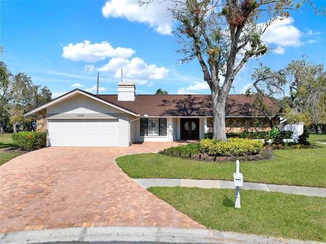 ranch-style house featuring a garage and a front yard