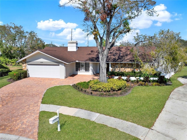 ranch-style house with a garage and a front lawn