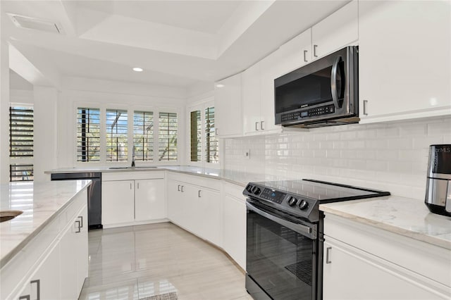 kitchen featuring stainless steel appliances, tasteful backsplash, white cabinets, and light stone counters