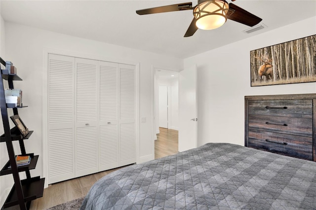 bedroom with a closet, ceiling fan, and light wood-type flooring