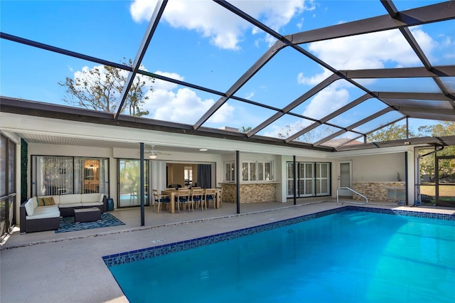 view of swimming pool featuring ceiling fan, outdoor lounge area, glass enclosure, and a patio area