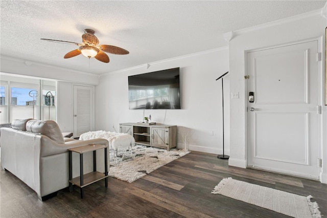 living area with dark wood-style floors, crown molding, a ceiling fan, and a textured ceiling