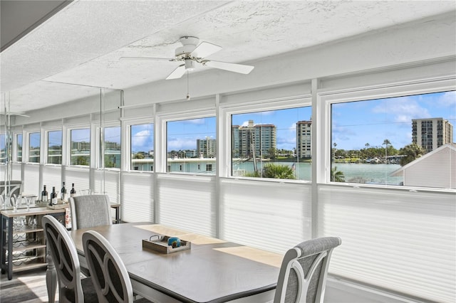 sunroom featuring a water view