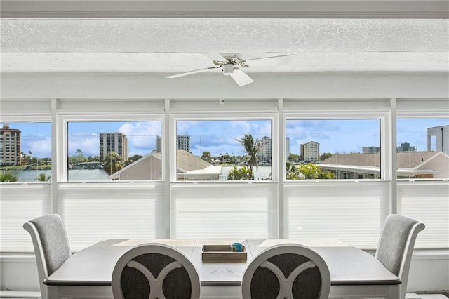 sunroom / solarium with a water view, a city view, and a healthy amount of sunlight