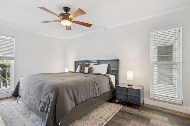 bedroom with a ceiling fan, wood finished floors, baseboards, and ornamental molding