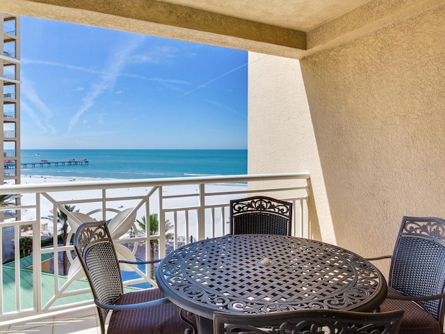 balcony featuring a water view and a view of the beach