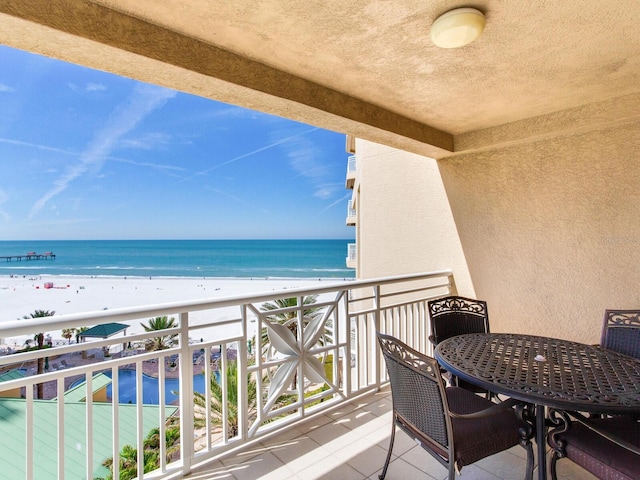 balcony featuring a beach view and a water view