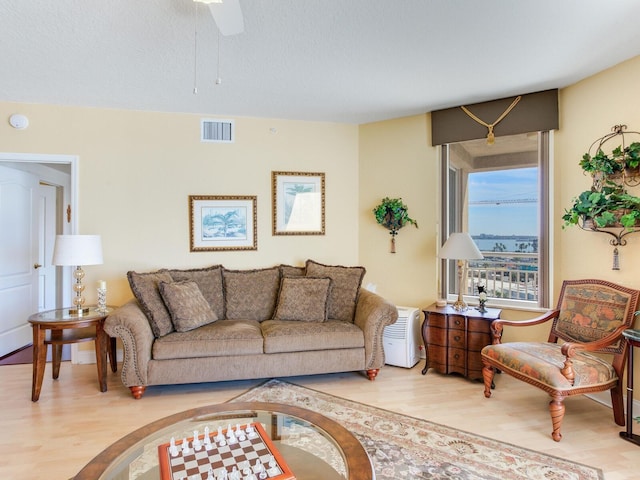 living room featuring a textured ceiling, wood finished floors, and visible vents