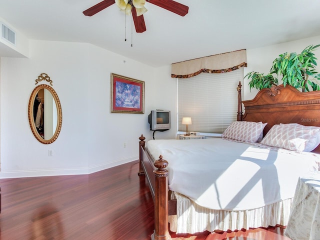 bedroom with dark wood-style floors, ceiling fan, visible vents, and baseboards