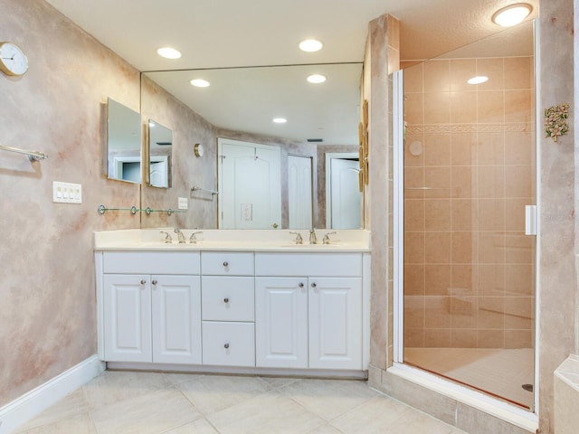 bathroom with double vanity, recessed lighting, a sink, and a shower stall