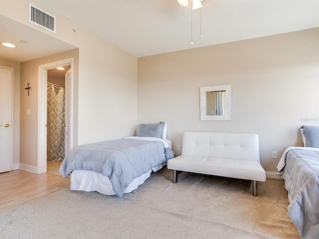 carpeted bedroom with wood finished floors, visible vents, and baseboards