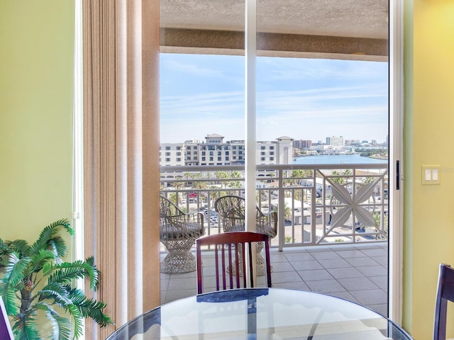 tiled dining room featuring a textured ceiling, a water view, and a city view