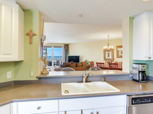 kitchen featuring pendant lighting, a notable chandelier, white cabinets, a sink, and dishwasher