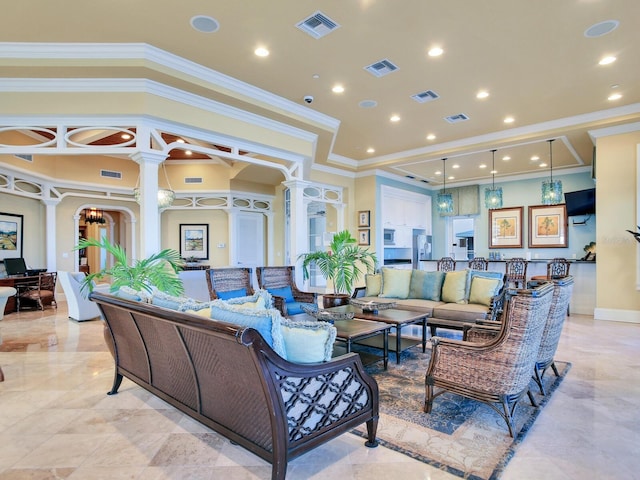 living area featuring ornate columns and visible vents