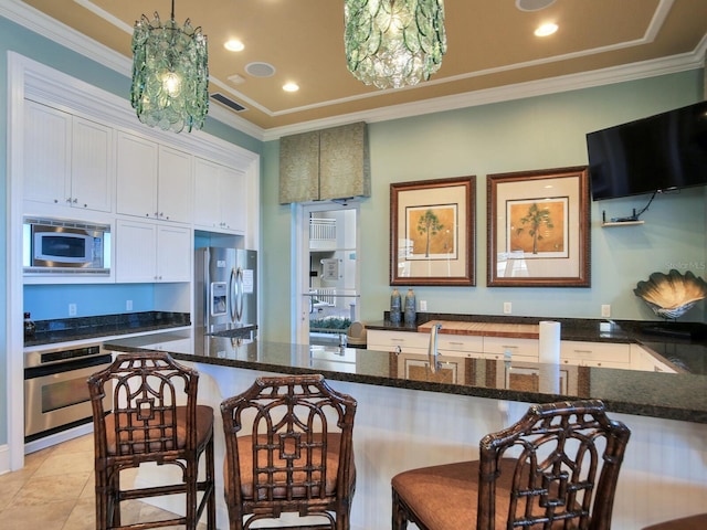 kitchen with white cabinets, pendant lighting, stainless steel appliances, and crown molding