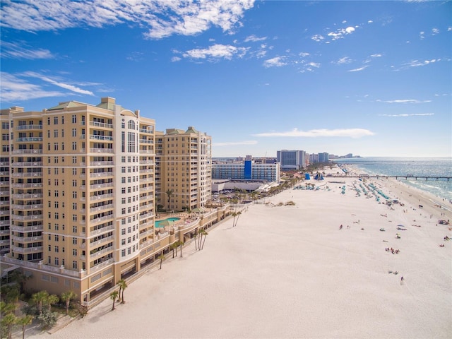 drone / aerial view featuring a view of the beach, a water view, and a view of city