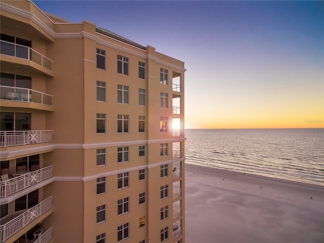 property at dusk with a water view