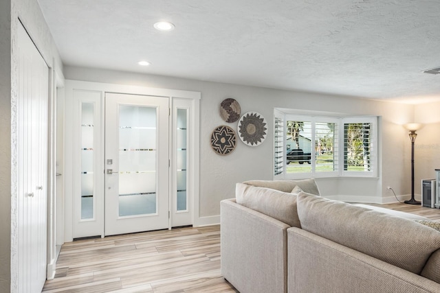 living room featuring a textured ceiling and light wood-type flooring