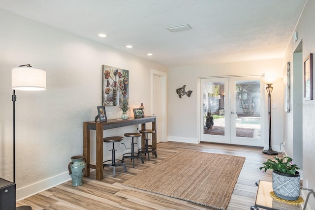 foyer featuring light hardwood / wood-style flooring and french doors