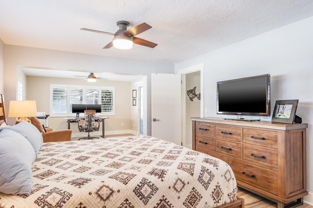 bedroom featuring ceiling fan and a textured ceiling