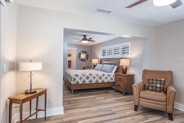 bedroom featuring ceiling fan, a textured ceiling, and light wood-type flooring