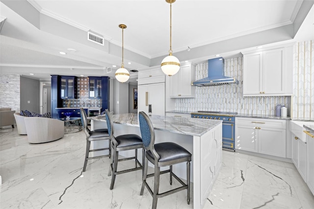 kitchen with marble finish floor, wall chimney exhaust hood, high end appliances, and crown molding