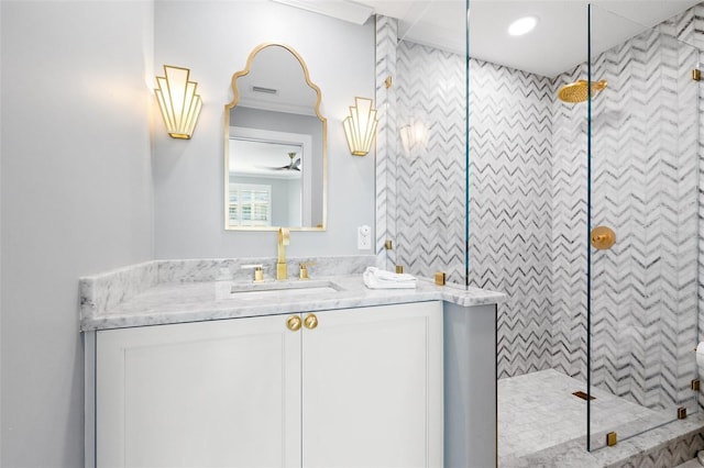 bathroom featuring tiled shower, vanity, visible vents, and crown molding